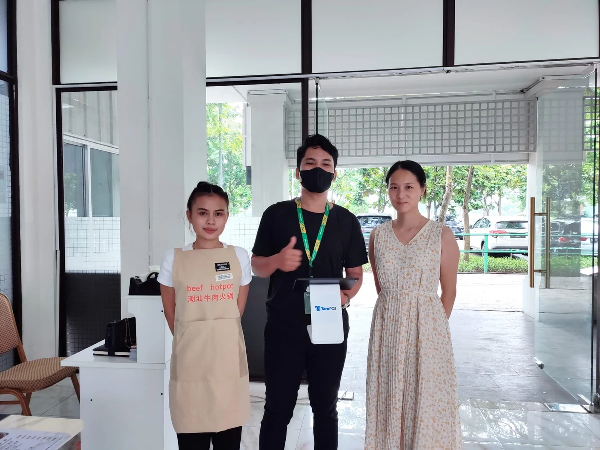 在 Chao Shan Hotpot Beef 与客户合影，展示收银设备。